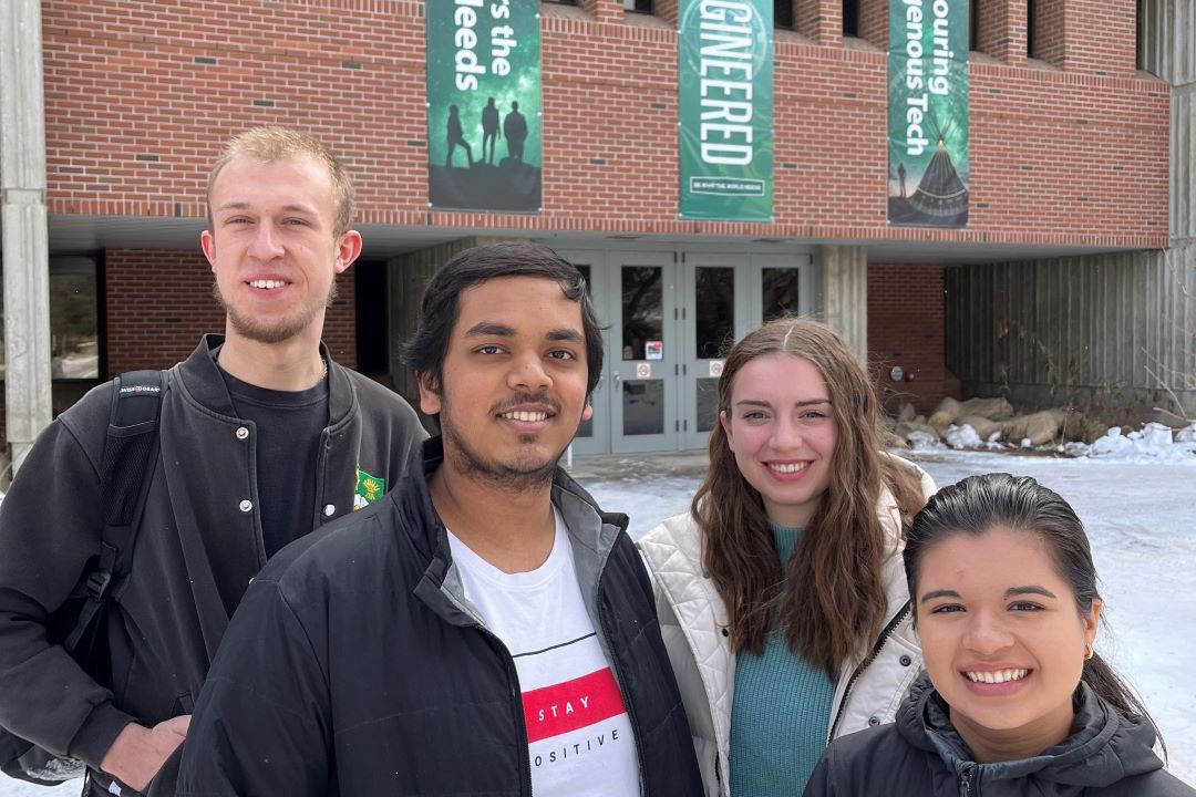 Four students standing in front of the Engineering Building 