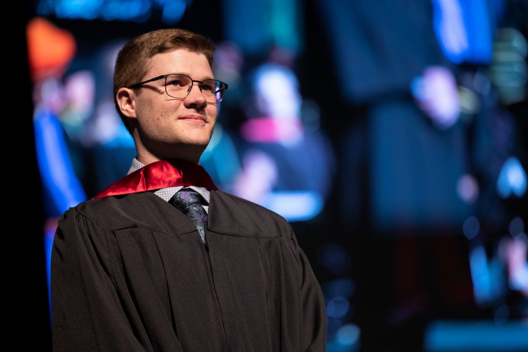 Photo of Alex Mayhew on stage at convocation.