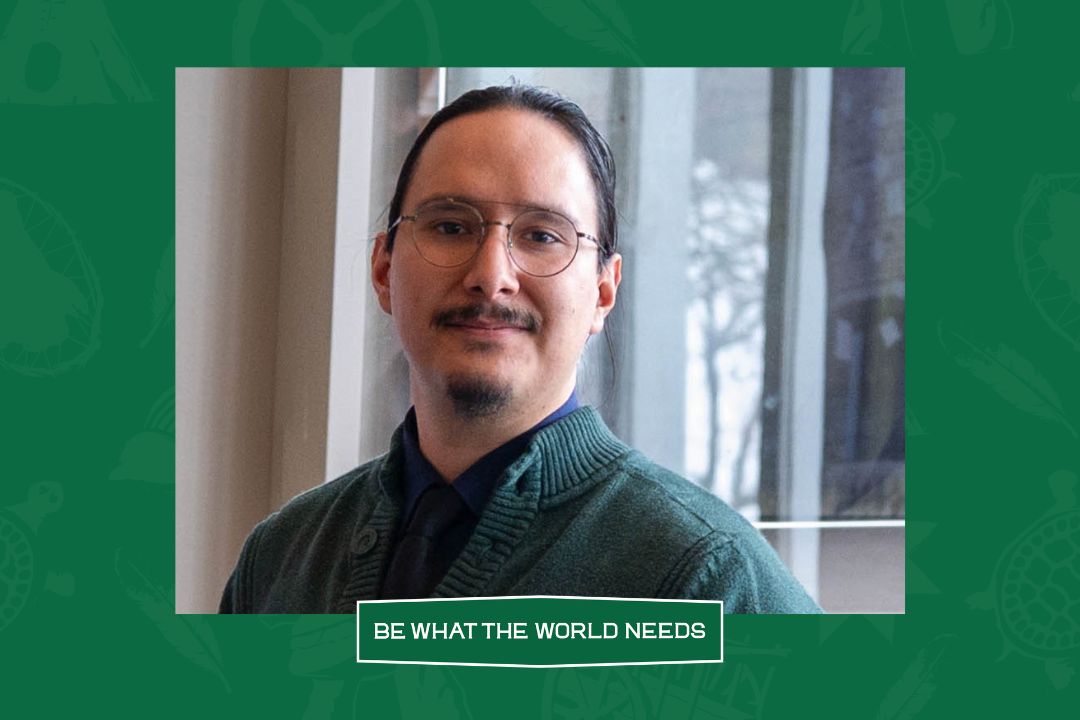 Photo of a man in his twenties wearing glasses, on a green background