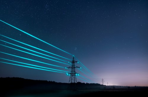 Transmission tower at night with glowing power lines